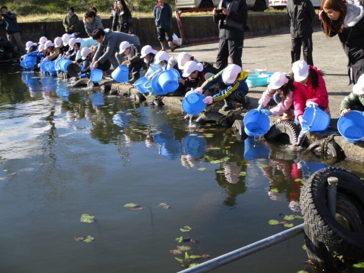 児童が育てた魚を諏訪湖に放流